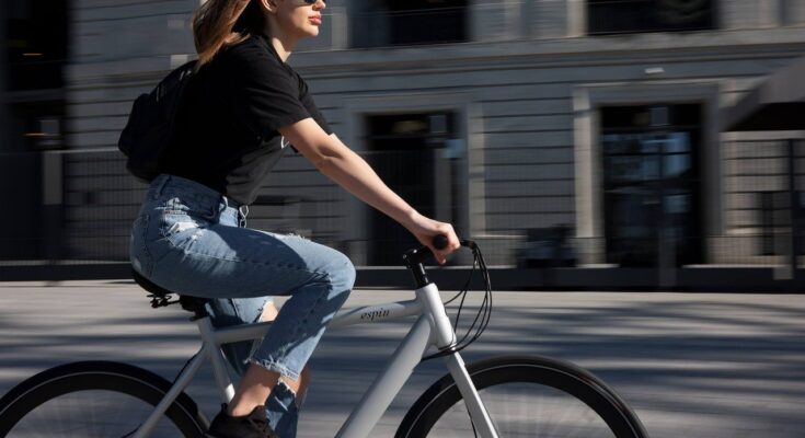 Kobieta jedzie rowerem przez ulice miasta